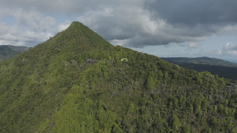 Aerial view of a person doing paragliding among the mountain, Mauritius.