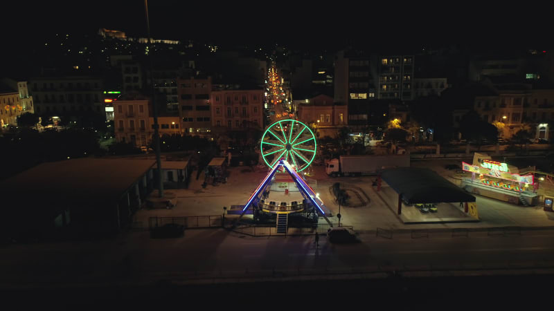 Aerial view of small amusement park with lights at night.