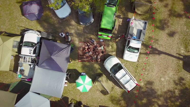 Aerial view of friends on large carpet at music festival.