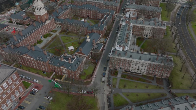 Aerial ascending footage of complex of historic red brick buildings in Harvard University campus. Boston, USA