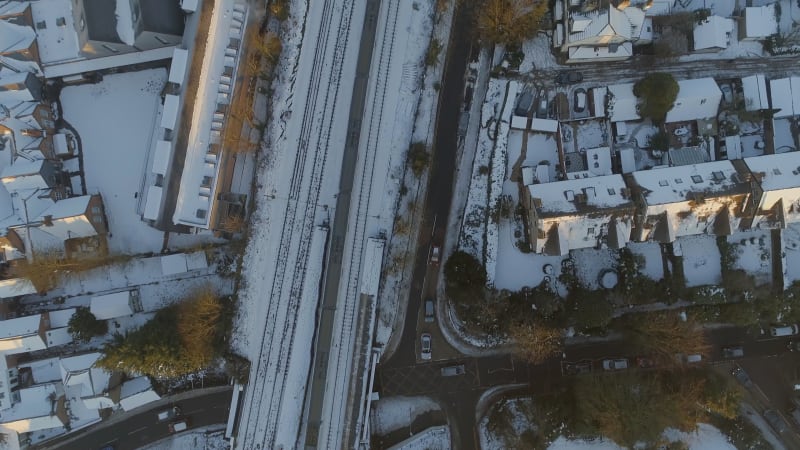 Commuter Train Departing a Snowy Urban Station