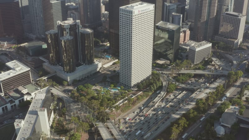 Freeway Traffic next to Downtown Los Angeles Skyline at blue sky sunny day in California, Drone View from the air