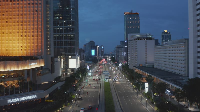 Aerial shot flying past Selamat Datang Monument in Jakarta towards multi lane highway through city center