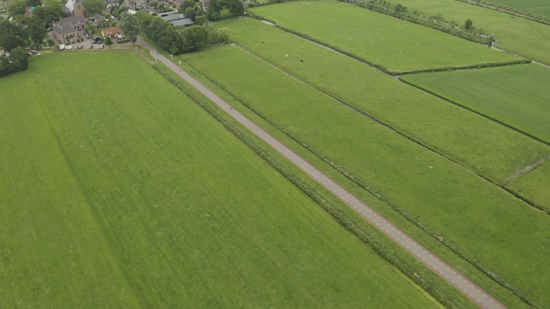 Cyclist driving into the village of Nieuwe Ter Aa in Netherlands