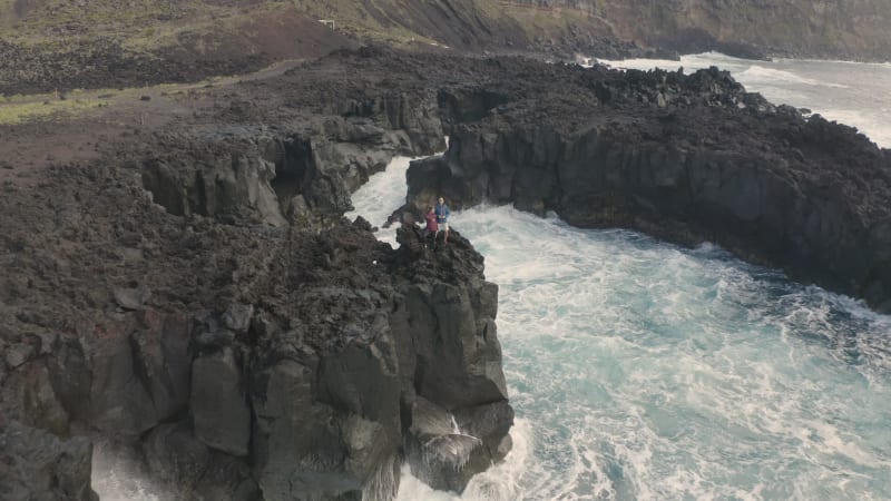 Aerial view of couple on coastal cliffs.