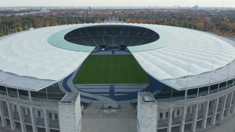 Beautiful Olympia Stadium in Berlin, Germany on blue sky day, Aerial Wide Establishing Dolly forward through symmetrical architecture of Stadium, October 2020