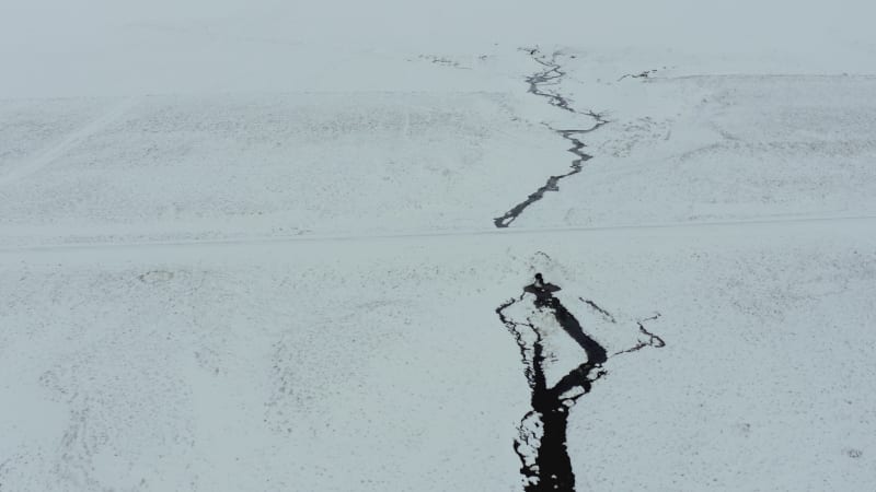 A River Running Through a Snowy Lava Field in Iceland From the Air