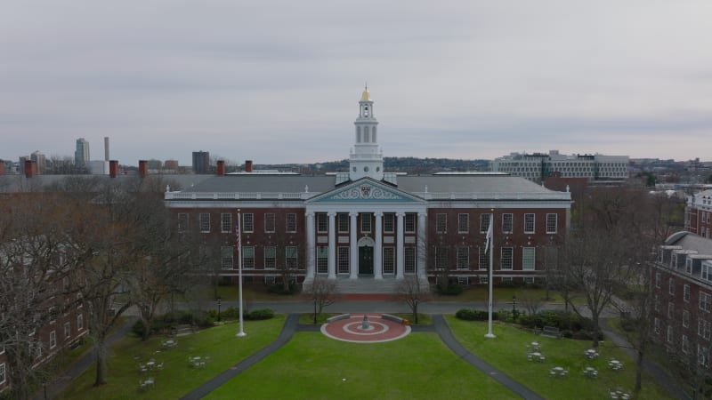 Dolly shot of Bloomberg Centre historic red brick building with columns and decorative entrance. Harvard University library. Boston, USA