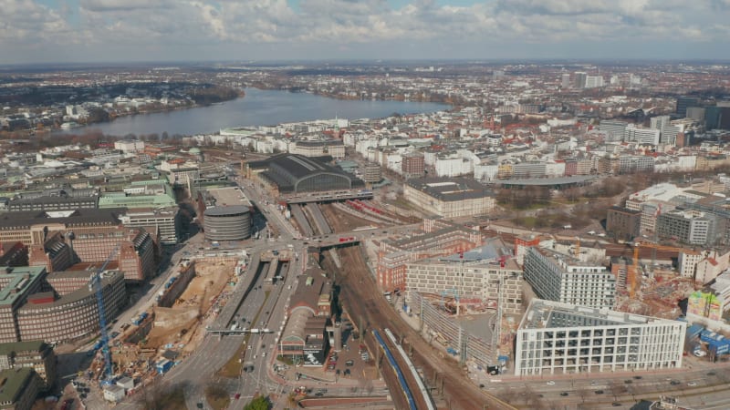 Two trains arriving at Hamburg main train station near large street intersection in city center