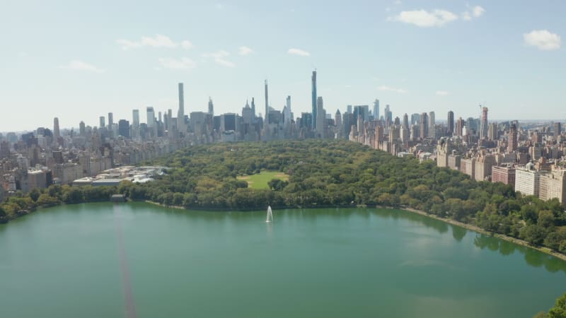 Flight over Central Park Lake in Public Park in Manhattan, New York City from Aerial Drone perspective on Summer Day