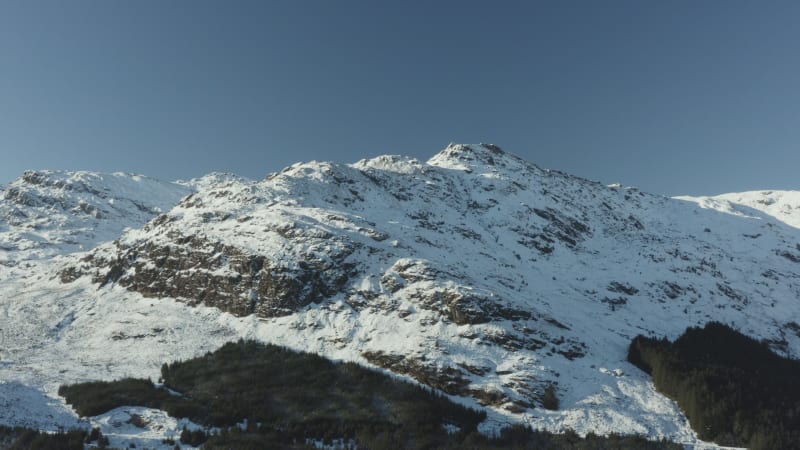 Flying towards snowy mountains on a clear winter day