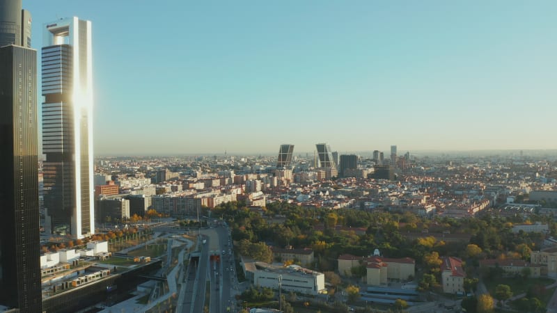 Forwards fly around skyscrapers in business hub. Aerial view of cityscape with Gate of Europe twin towers.