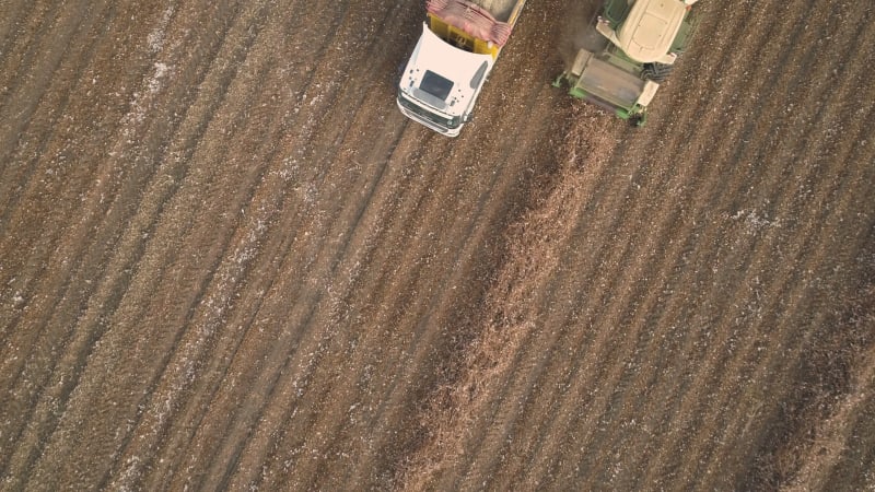 Aerial view of a tractor and a lorry working in a field, Kibbutz Saar, Israel.