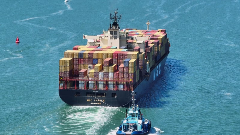 A Container Vessel Being Assisted into Port By a Tug Boat