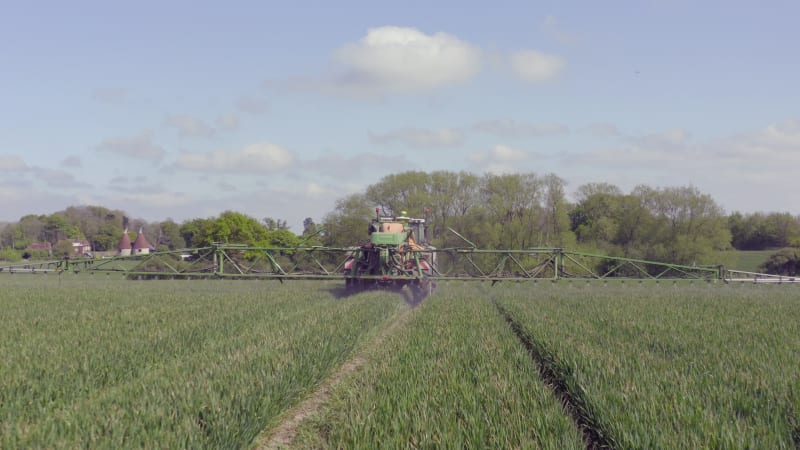 Tractor Spraying a Controversial Glyphosate Herbicide on Agricultural Land