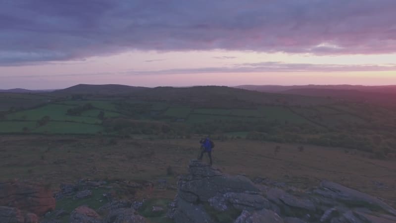 Photographer in Dartmoor National Park at sunrise, Devon, England, UK. Aerial drone view