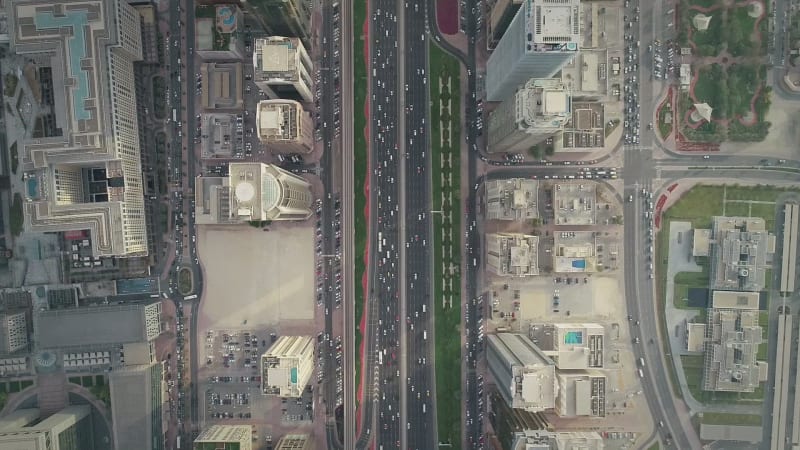 Aerial view of Dubai colourful skyscrapers, and long busy road.