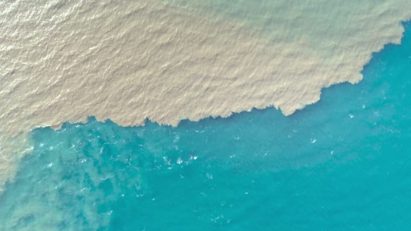 Aerial view of river and sea waters mixing in Rio.