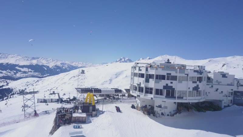 Pull back shot of upper cable car station and restaurant. Revealing winter mountain landscape. sunny day with clear sky. Laax, Switzerland