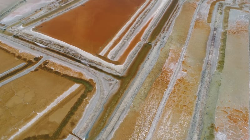 Aerial view of big salt industry near a coastal village.