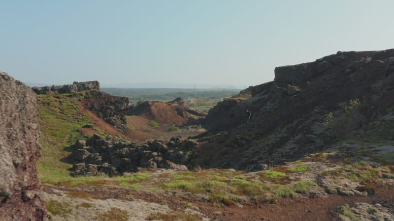 Birds eye drone view man backpacker hiking walkway in desert rock exploring beauty in nature in Iceland. Aerial view hiker exploring the wild landscape of Iceland alone