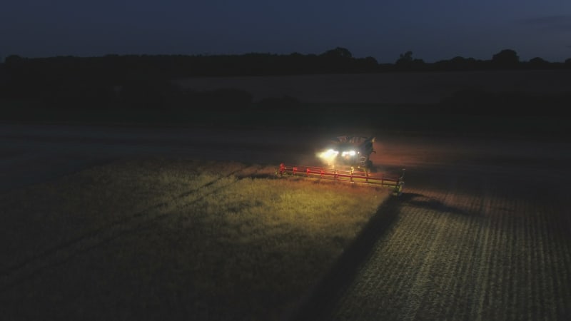 Night Time Harvest Using a Large Combine Harvester in a Field