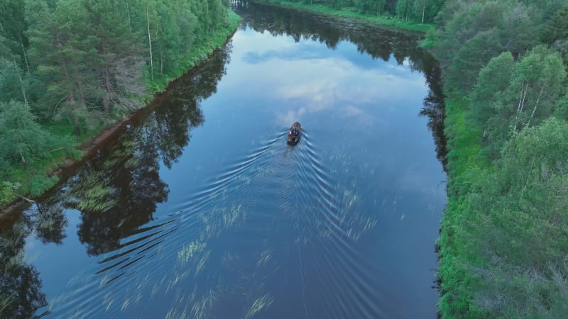 Aerial view of a small boat sailing a river in Overtornea, Sweden.