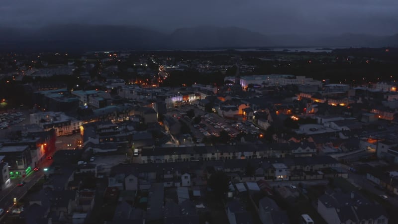 Aerial panoramic shot of town after sunset. Evening footage of colour illuminated facades in city centre. Killarney, Ireland