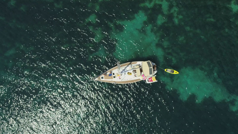 Aerial view above sailboat swinging on the coast of Varko.