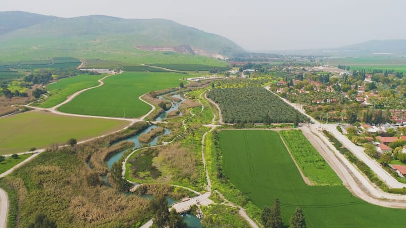 Aerial view of cultivated fields with hills in the background and Kibbutzim.