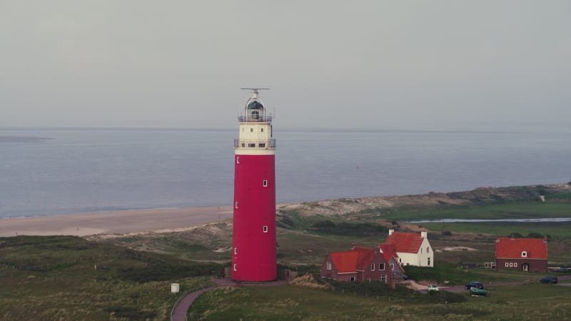 Circling a Red Lighthouse in Front of a Villa, Beach