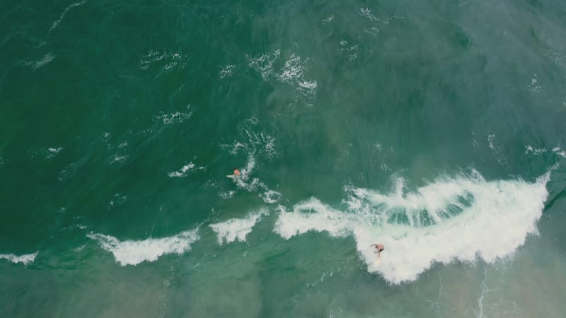 Surfer being swept off the board by a strong wave