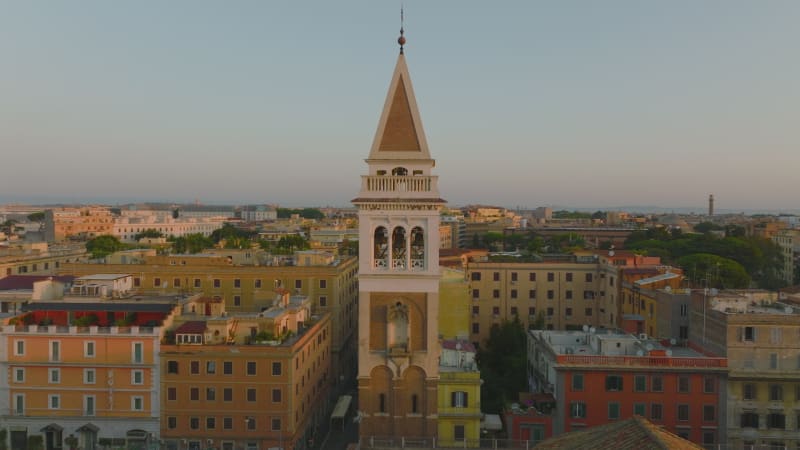 Fly around beautiful tower, morning city in background. Circular aerial view of buildings in urban borough. Rome, Italy