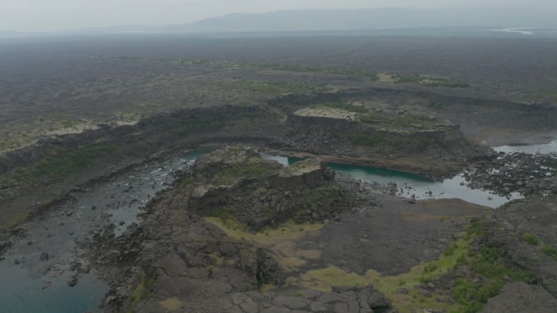 Birds eye surreal panorama of black rock basalt cliffs in Iceland. Drone view of Aldeyjarfoss waterfall highlands with river flowing and volcanic formations