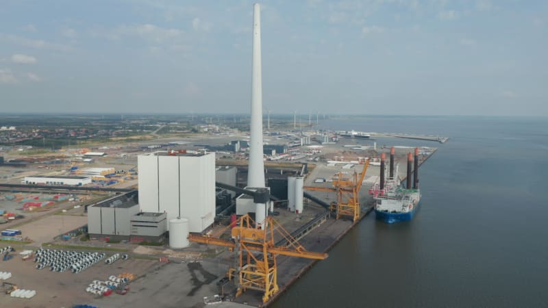 Slow rotation birds eye over the Esbjerg harbor and the chimney of the Steelcon coal fired power station. Aerial view revealing the harbor in the background, the most important of the north sea