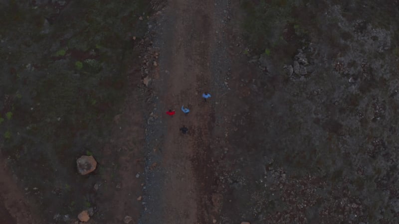 Top down view group of tourist trekking isolated rocky highlands in Iceland. Overhead view four people walking trail enjoying healthy lifestyle