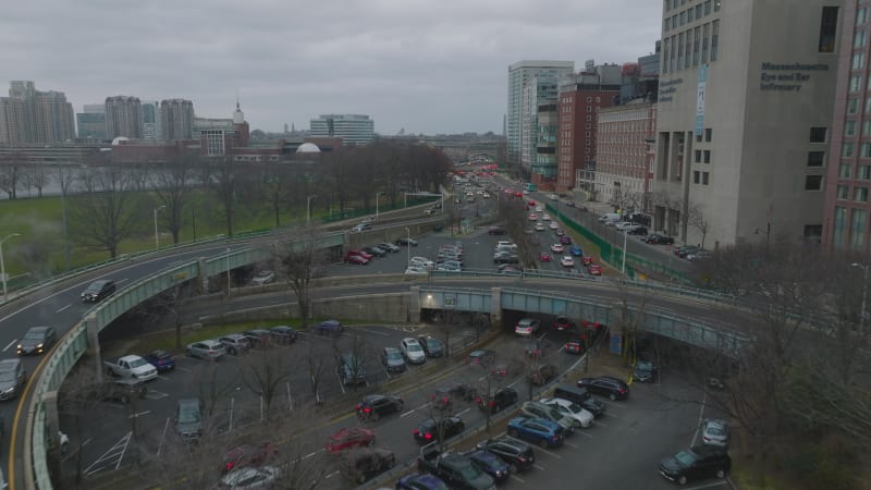 Transport infrastructure in urban borough. Forwards fly above multilane road with heavy traffic on cloudy day. Boston, USA