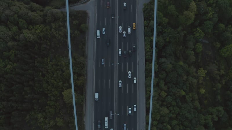 Cars driving onto Bridge towards City Skyline in Istanbul, Turkey over Bosphorus, Aerial birds eye view tilt up