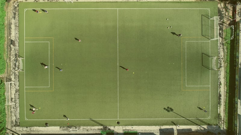 Aerial view of people training football in a beautiful football camp.