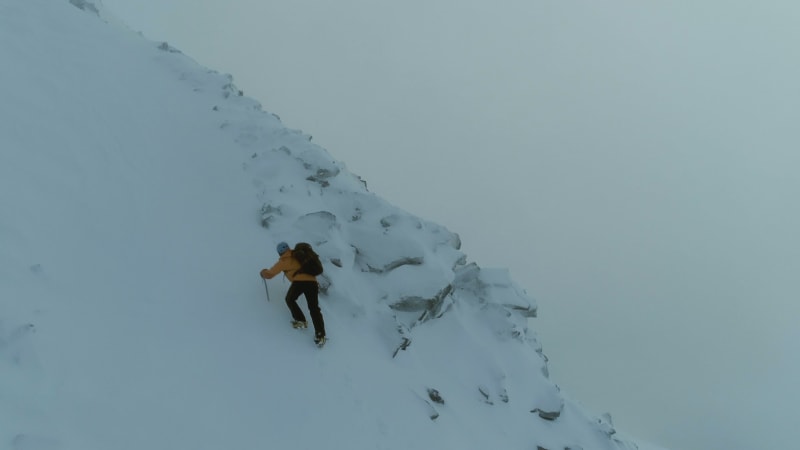 Mountain Climber on a Steep Snowy Ascent