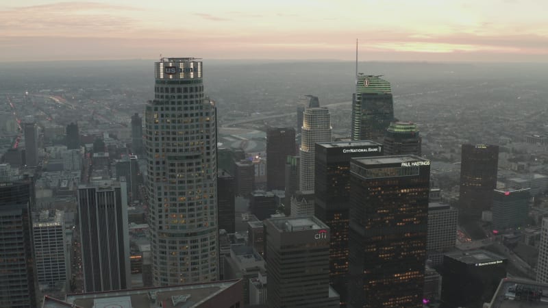 AERIAL: Breathtaking reverse flight from skyscrapers in Downtown Los Angeles, California at beautiful Sunset