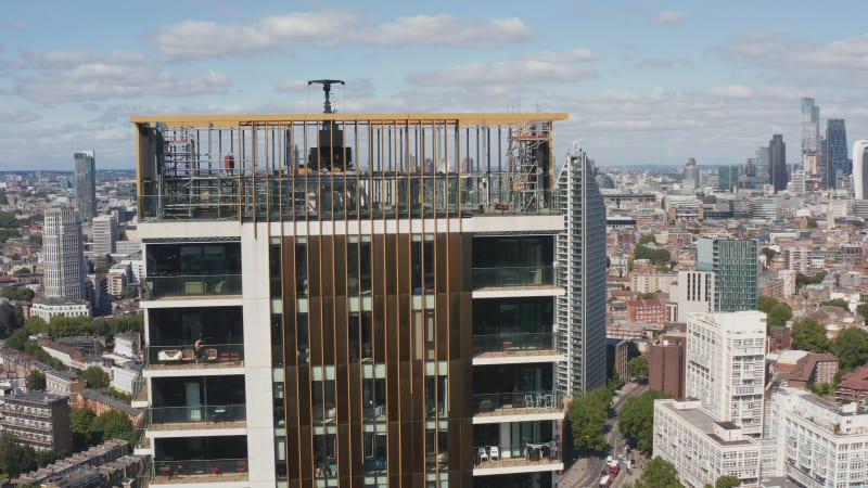 Fly around top platform of One The Elephant skyscraper. Repairing of building or doing maintenance. Panoramic view of city. London, UK