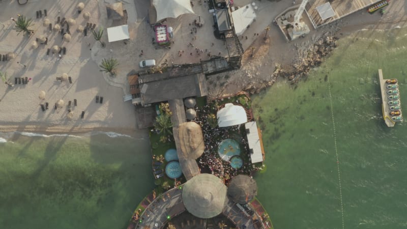 Tropical Location of a Beach Club in Croatia in afternoon sunset and turquoise ocean waves, Aerial Top View