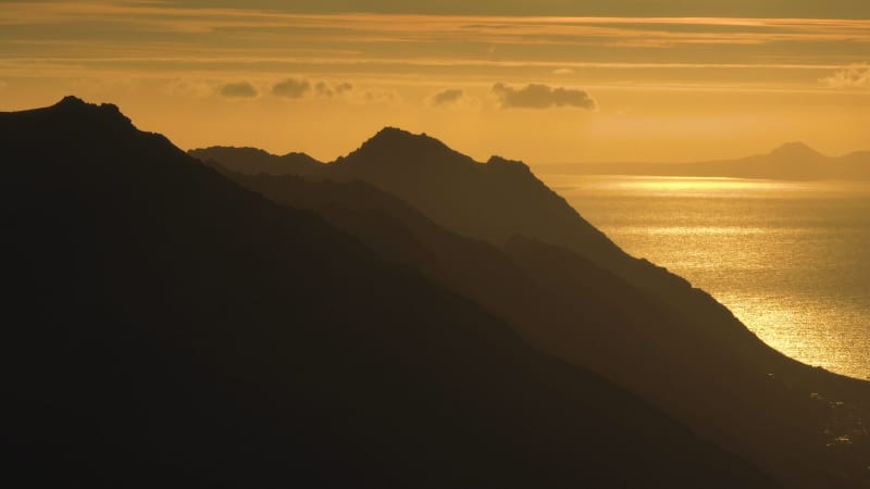 Aerial footage of Hilly mountains and Sea at Sunset, Lowry's Pass, South Africa