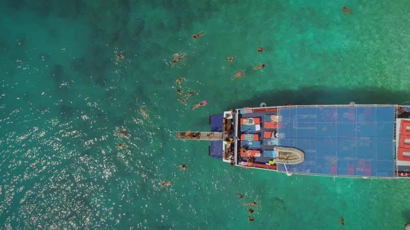 Aerial view of people in ferry diving on the sea, Ithaki island.