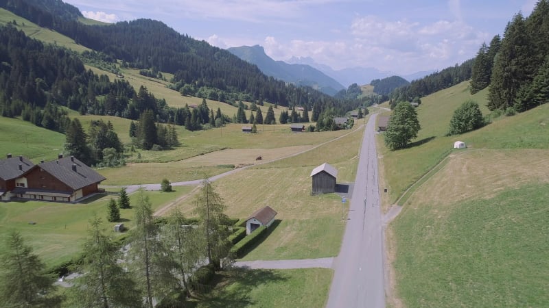 Aerial View of a Valley in Switzerland with Chalets and a Mountainous Landscape