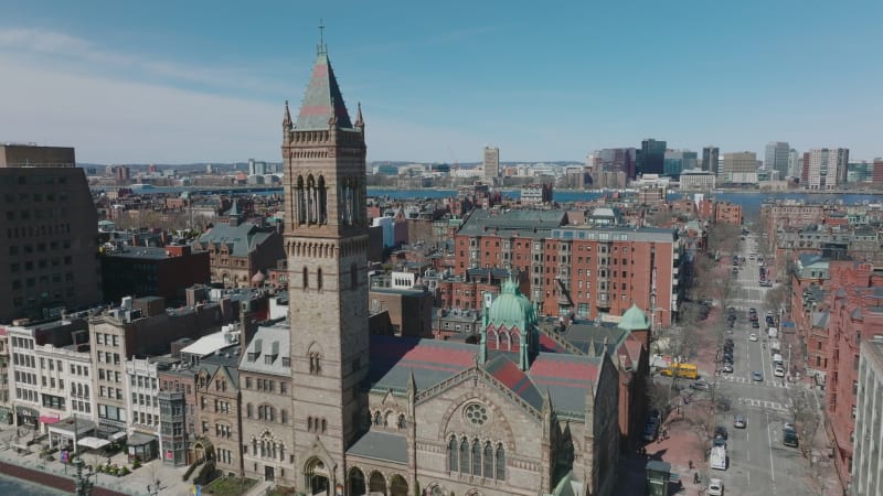 Fly around tall tower of Old South Church. Revealing panoramic view of red brick houses in residential urban neighbourhood. Boston, USA