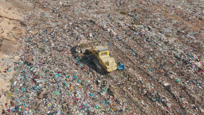 Aerial einer gelben Müllpresse auf einer kommunalen Mülldeponie.
