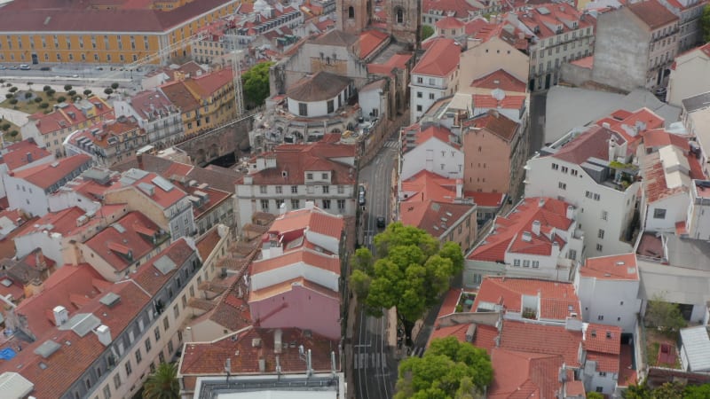 Aerial view of downtown with old roman catholic Lisbon Cathedral also know as Saint Mary Major. Drone flying forwards over houses and streets. Lisbon, capital of Portugal.