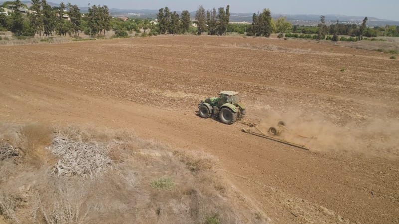 Aerial view of a tractor ploughing an empty field, Kibbutz saar, Israel.